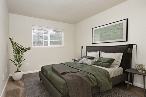 Bedroom with queen size bed, two side tables, and window.
